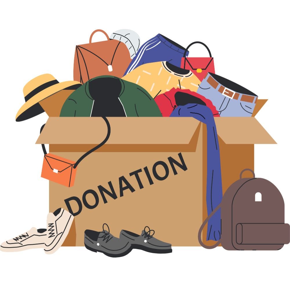 A cardboard box full of donations, including bags, clothes and shoes.